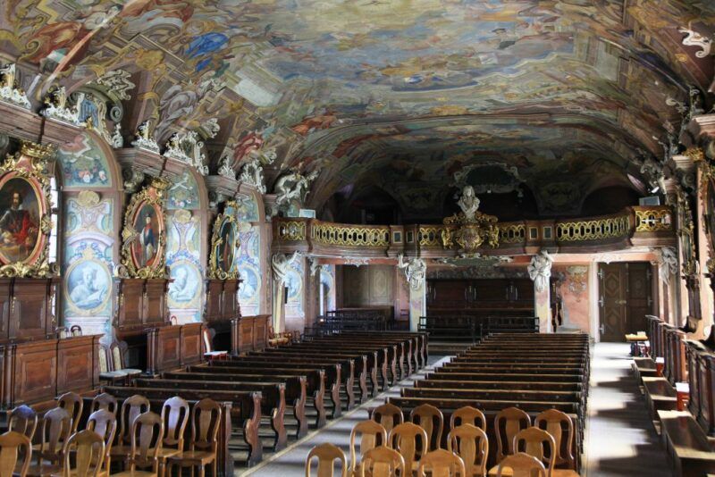 Barokowa aula z pięknymi rzeźbami, zdobieniami oraz malowidła przedstawiające postacie.