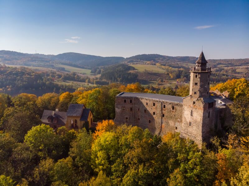 Widok na zamek na tle gór przy jesiennej pogodzie