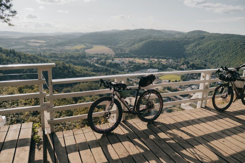 Zdjęcie przedstawia rower typu gravel stojący oparty o barierkę na obrywie skalnym w Bardzie