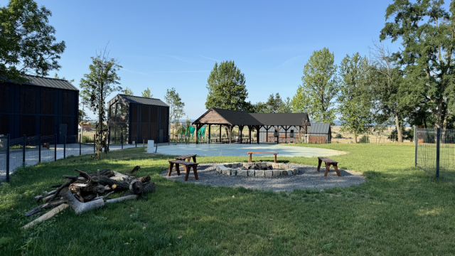Miejsce campingu, na zdjęciu kilka domków oraz miejsce na ognisko.