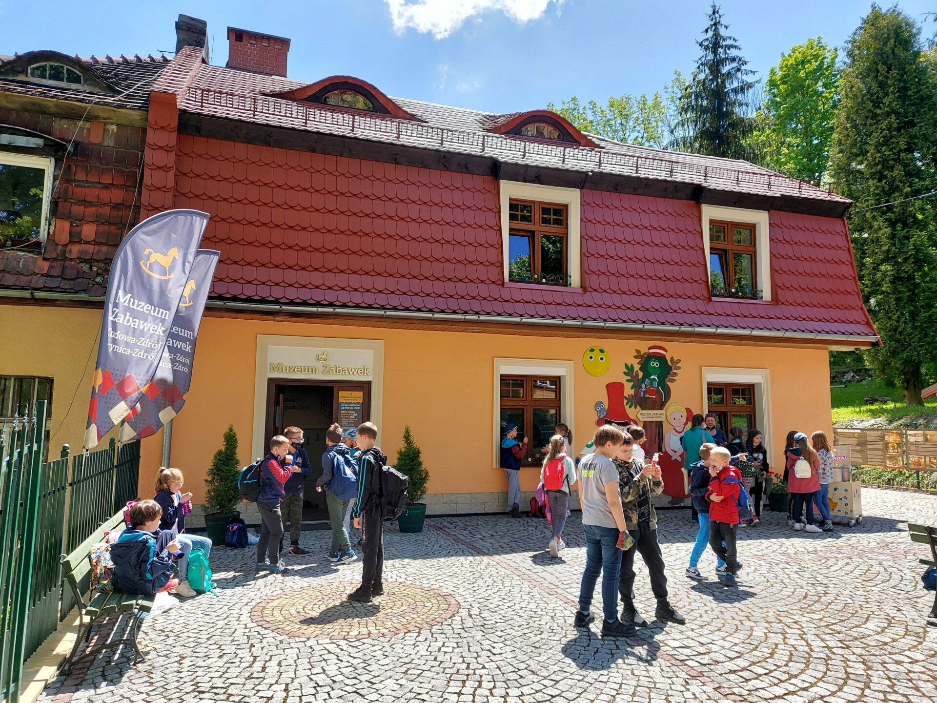 Wycieczka szkolna wchodzi do budynku Muzeum Zabawek w Kudowie-Zdroju