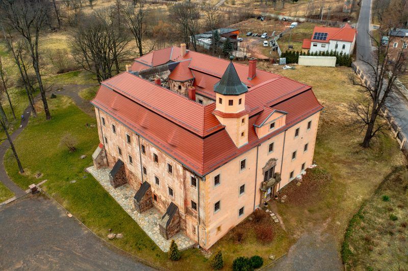 Na zdjęciu z lotu ptaka widać otoczony zielenią Pałac Struga – okazały, jasny budynek o symetrycznej bryle z wieżyczką, dziedzińcem i malowniczym parkiem rozciągającym się wokół niego.