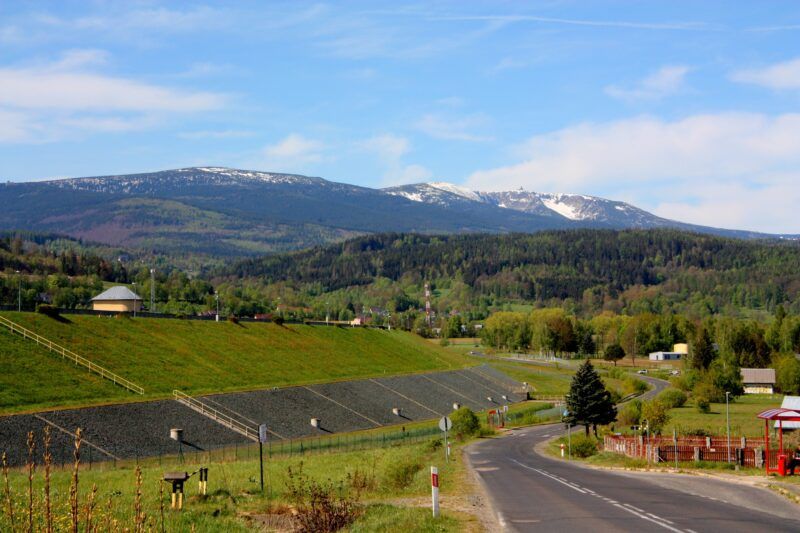 Droga asfaltowa prowadząca w stronę pasma gór.