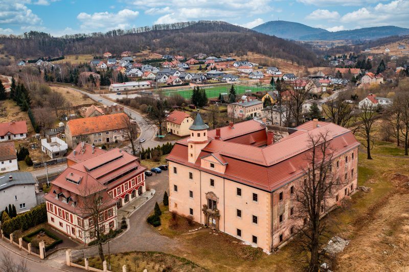 Na zdjęciu z lotu ptaka widać otoczony zielenią Pałac Struga – okazały, jasny budynek o symetrycznej bryle z wieżyczką, dziedzińcem i malowniczym parkiem rozciągającym się wokół niego.