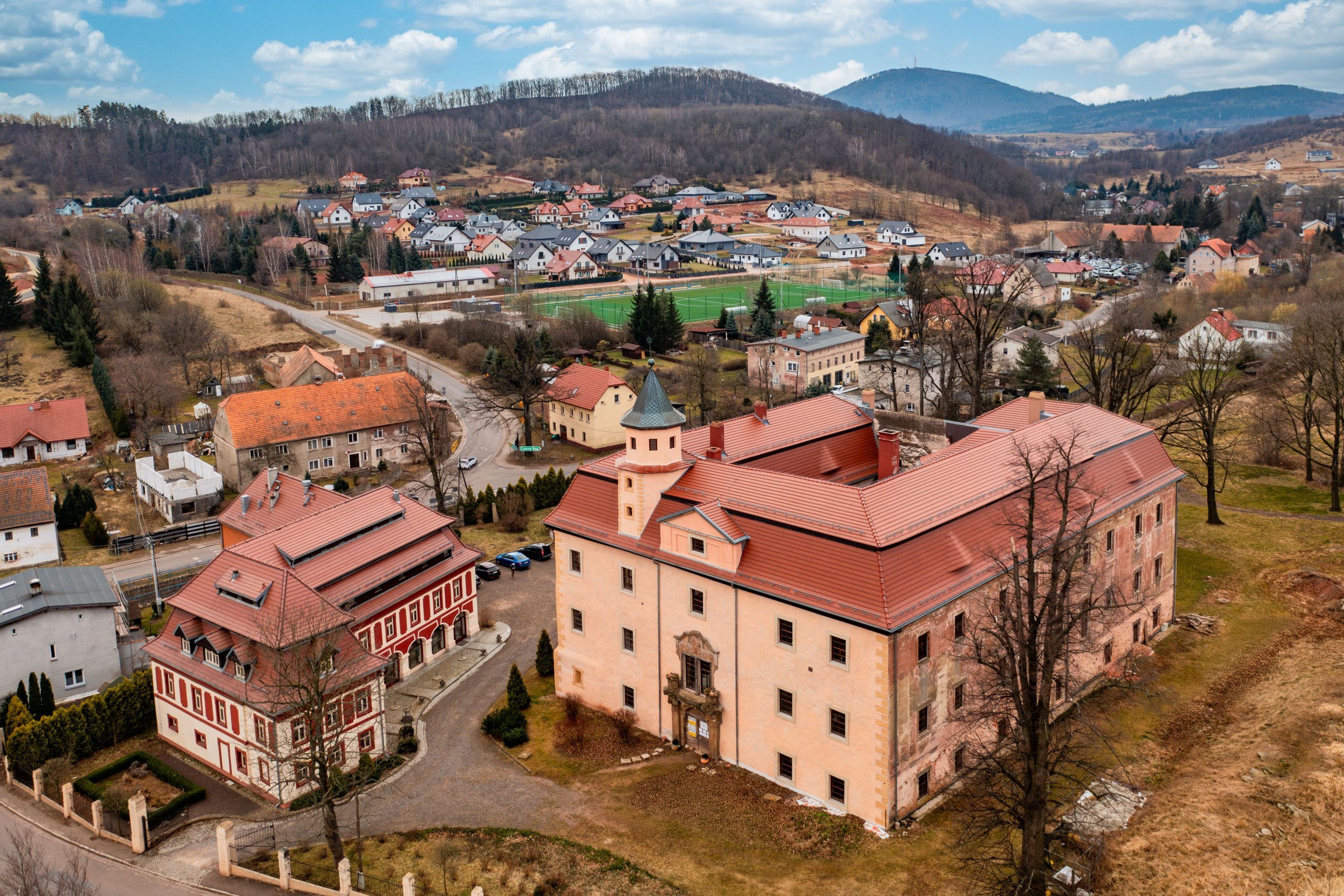 Na zdjęciu z lotu ptaka widać otoczony zielenią Pałac Struga – okazały, jasny budynek o symetrycznej bryle z wieżyczką, dziedzińcem i malowniczym parkiem rozciągającym się wokół niego.