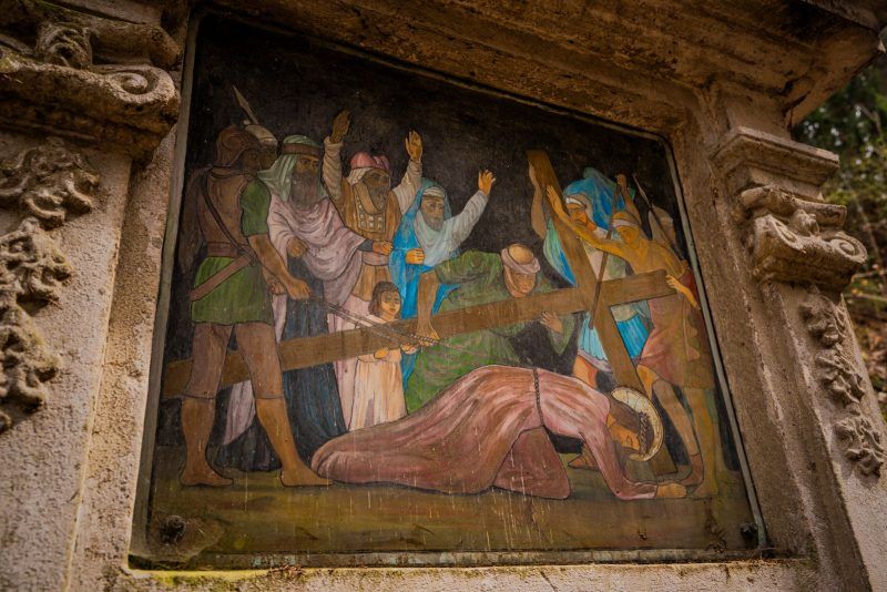 Widok na górską drogę Krzyżową w Bardzie z turystą maszerującym w oddali