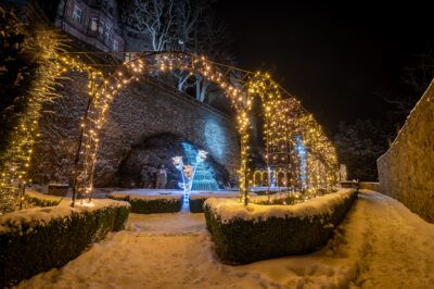 Tarasy zamkowe w zimowej aurze udekorowane mnóstwem lampek o ciepłej barwie.