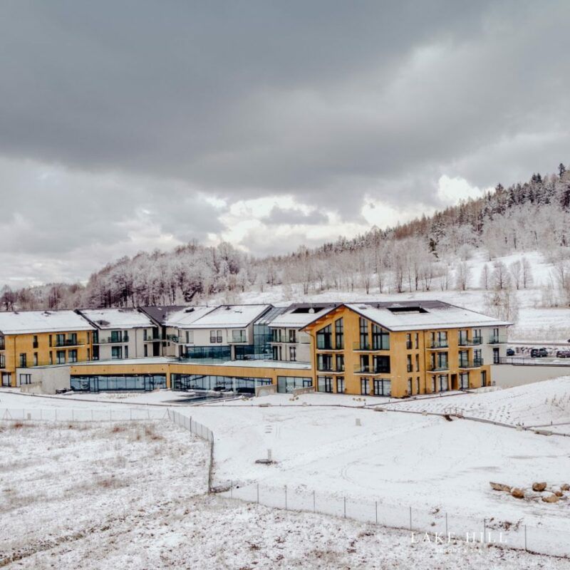 Widok z oddali na hotel w zimowej aurze, pokryty śniegiem.