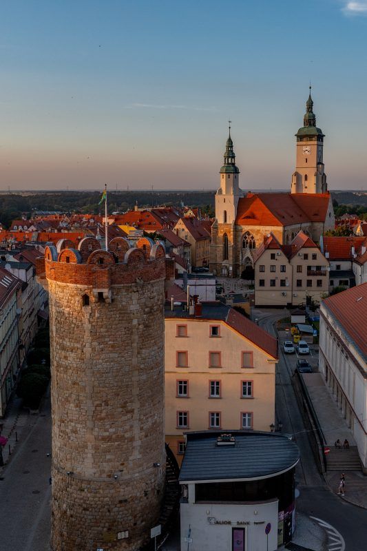 Widok z drona na zabudowę centrum Złotoryi z Basztą Kowalska widoczną na pierwszym planie