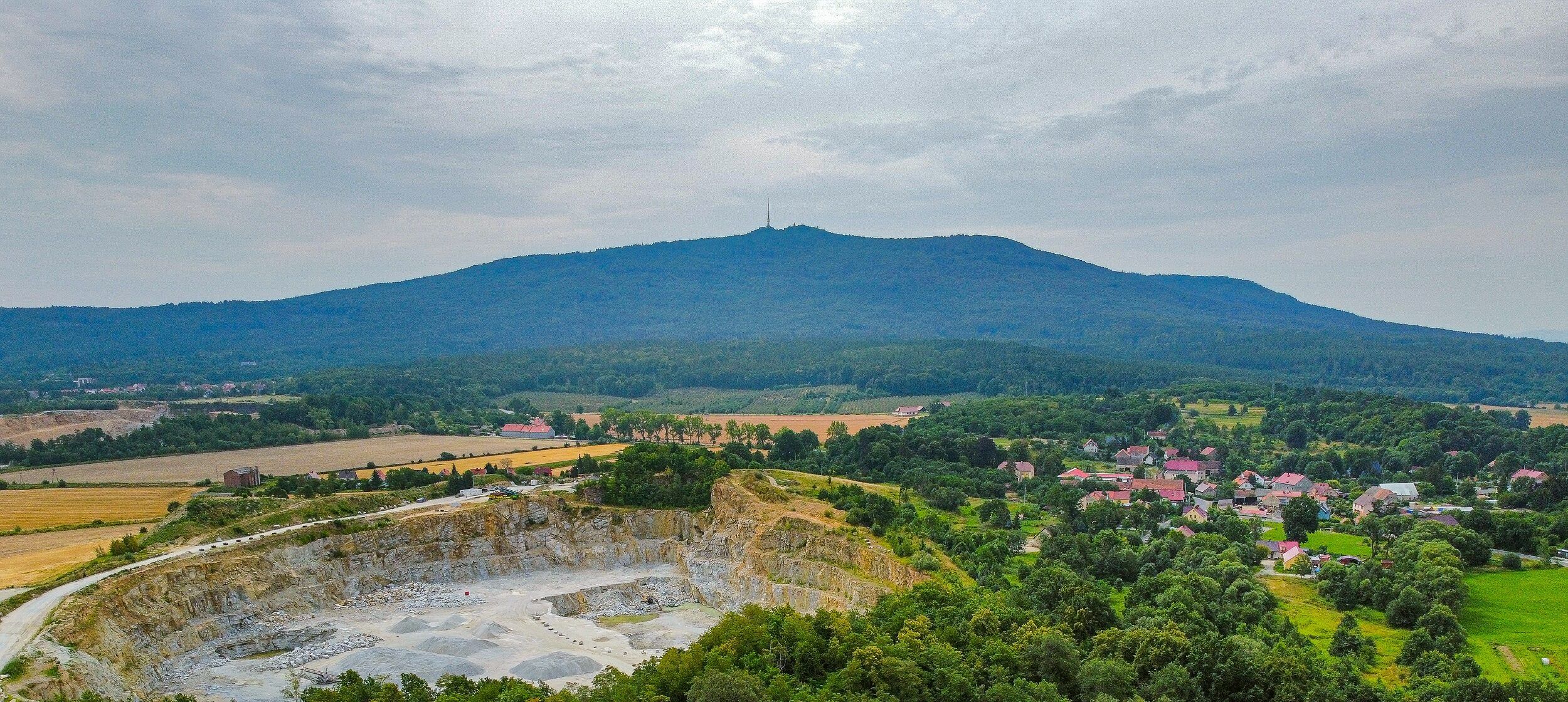Widok z lotu ptaka na górę Ślężę, domy oraz lasy.