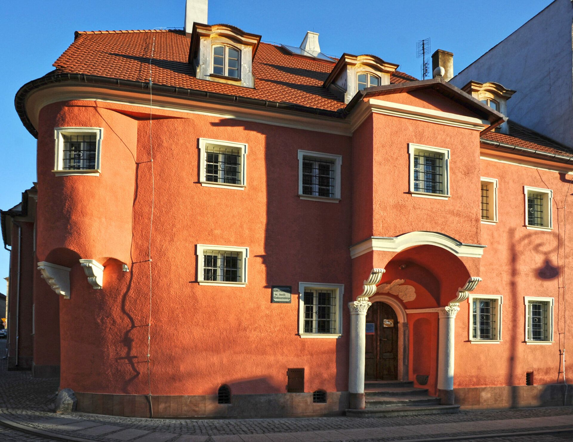duży budynek w kolorze jasno brązowym, z wieloma małymi kwadratowymi oknami
