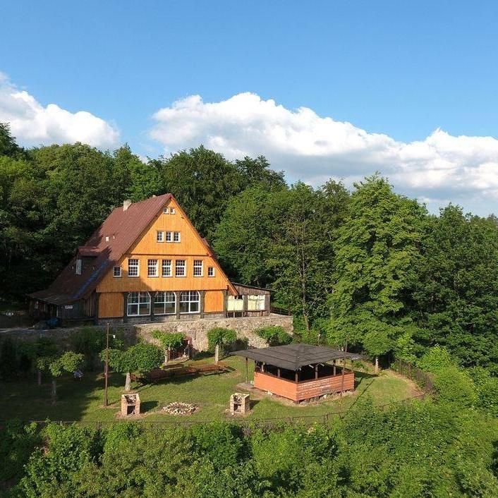 Dom Turysty z lotu ptaka, otoczony zielenią.