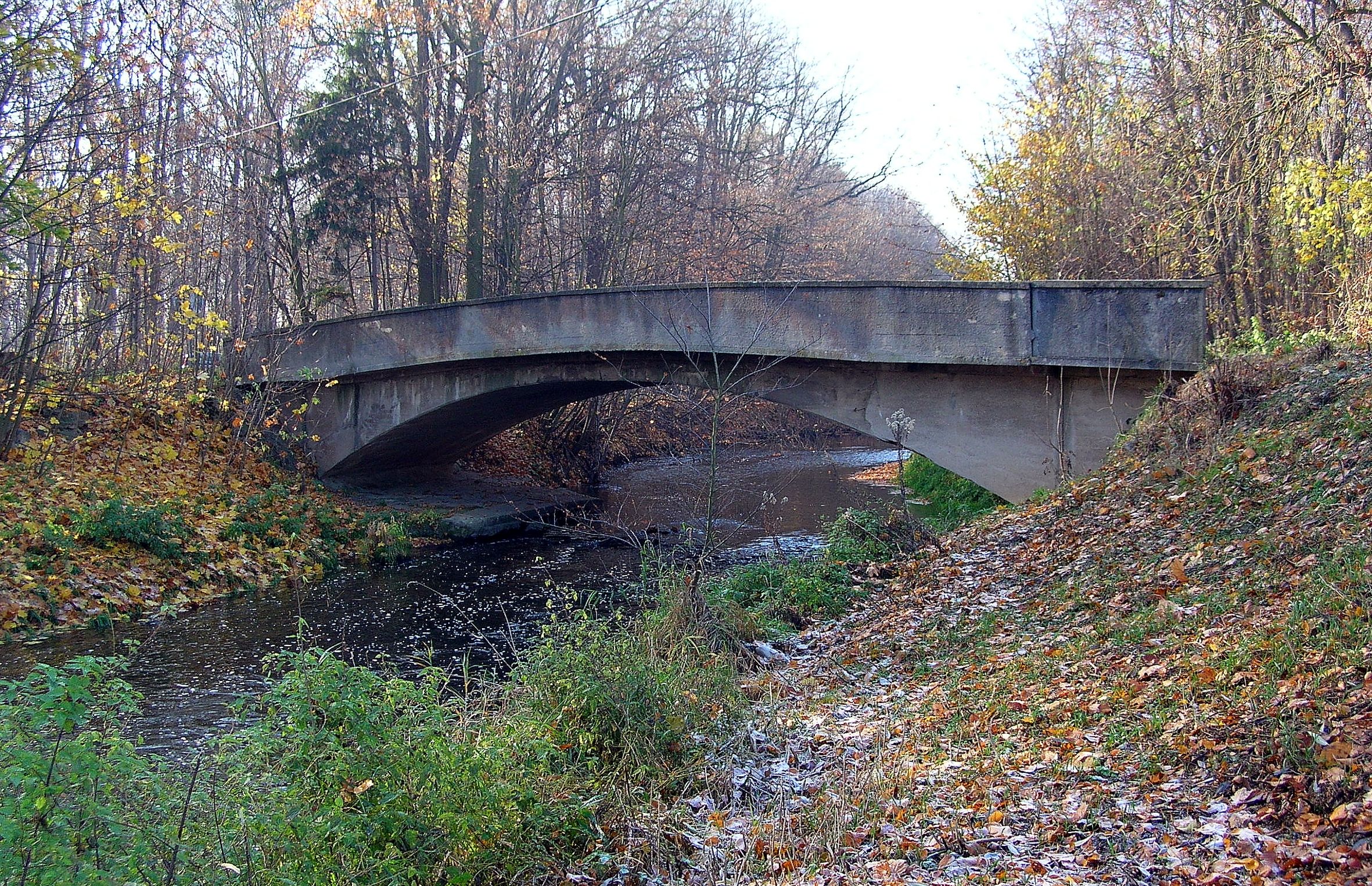 zdjęcie mostu nad rzeką w pochmurny dzień