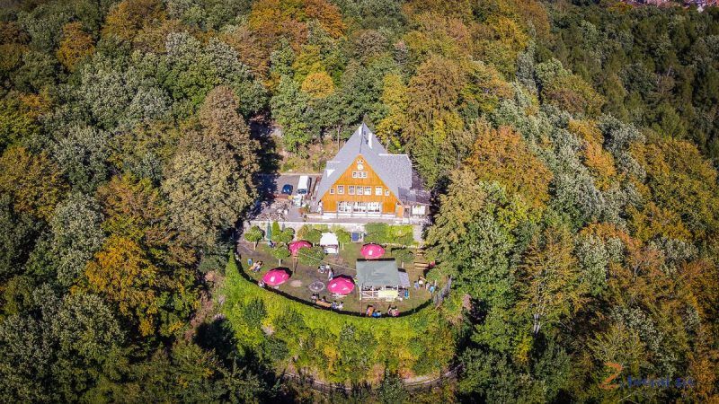 widok z drona na pomarańczowe schronisko otoczone lasami