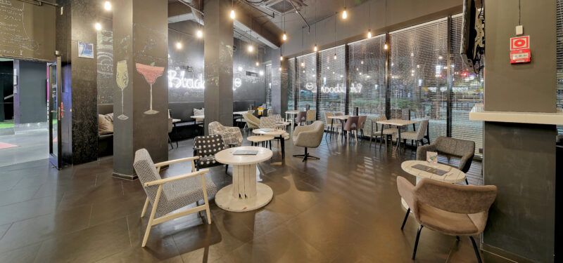 Wnętrze nowoczesnej restauracji. Dekorację stanowią duże szpule na druty zamiast stolików, różne formy foteli oraz krzeseł.
