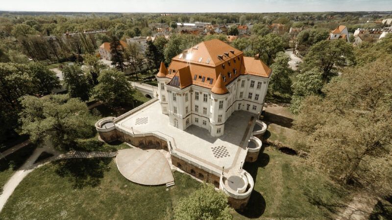 Zdjęcie z drona na zabytkowy pałac we Wrocławiu z widocznym całym założeniem oraz parkiem wokół
