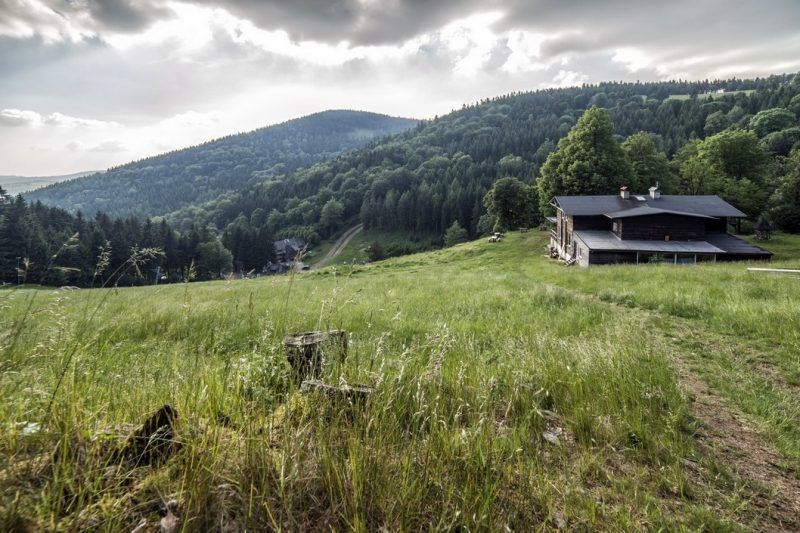 zdjęcie przedstawia panoramę gór, ze schroniskiem w tle. Pogoda jest zachmurzona