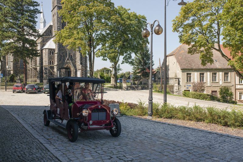 Retro pojazd podczas wycieczki na tle Złotego Stoku
