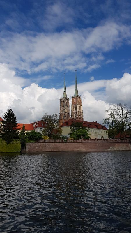 zdjęcie wykonane z poziomu wody przedstawiające wysoką katedrę na ostrowie tumskim we wrocławiu