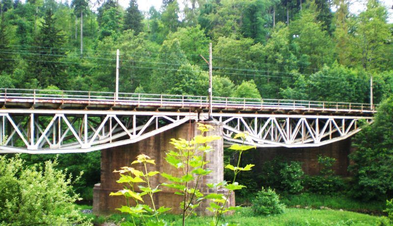 most kolejowy nad rzeką mający konstrukcje z metalowych prętów