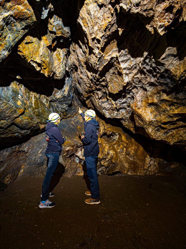 Dwóch turystów na podziemnej trasie turystycznej w Jaskini Radochowskiej