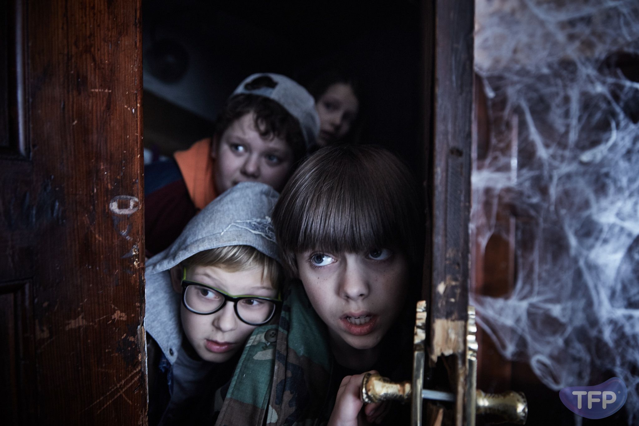 Kadr z filmu przedstawiający dzieci otwierające stare drzwi.