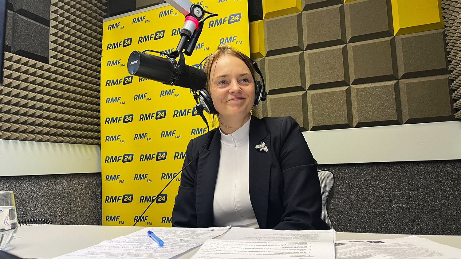 Grafika ilustracyjna z kobietą uśmiechającą się w studiu radiowym