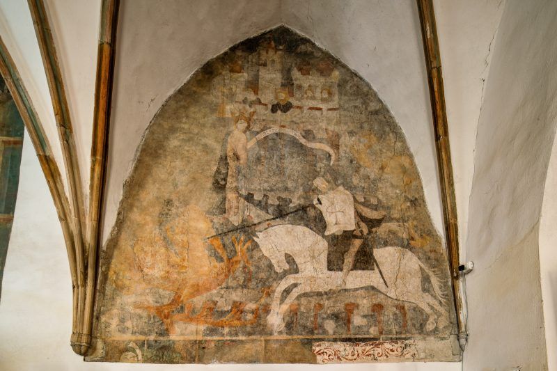 Gotyckie freski przedstawiają sceny Męki Pańskiej i św. Jerzego walczącego ze smokiem