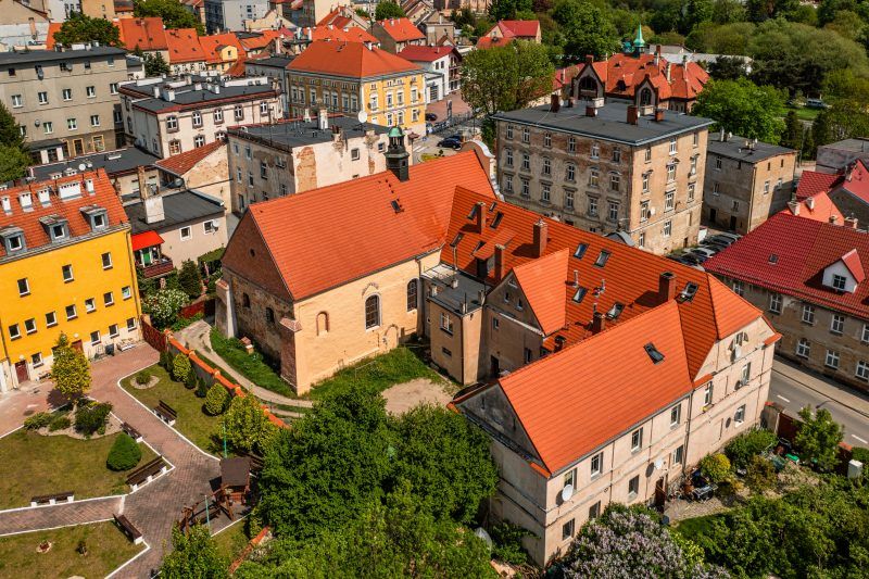 Widok z lotu ptaka na cerkiew - budowla z kamienia i cegły, o gotyckim prezbiterium z ostrołukowym portalem i strzelistym, oskarpowanym zewnętrzem