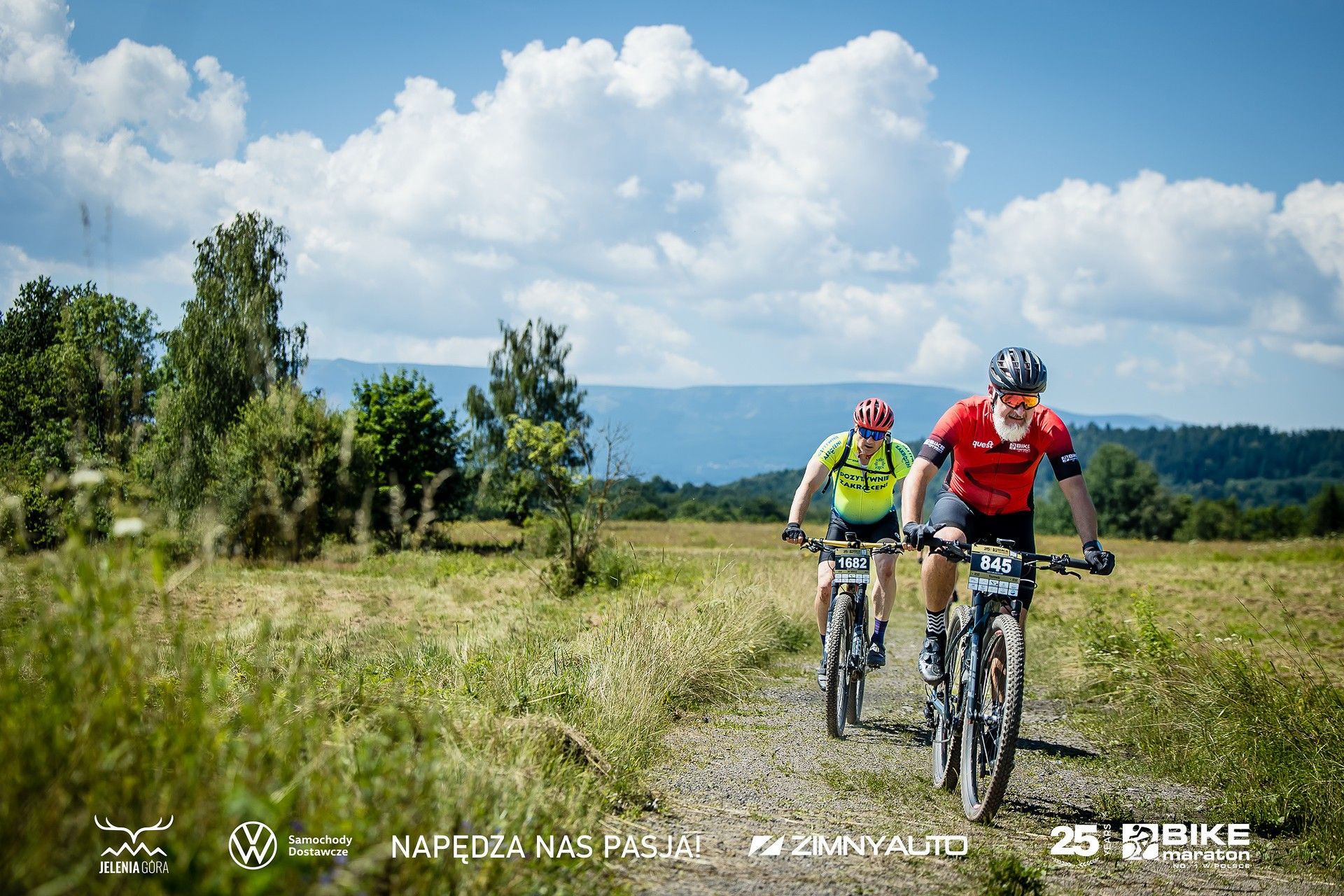 Zdjęcie dwóch rowerzystów podczas wyścigu na tle dolnośląskiego krajobrazu