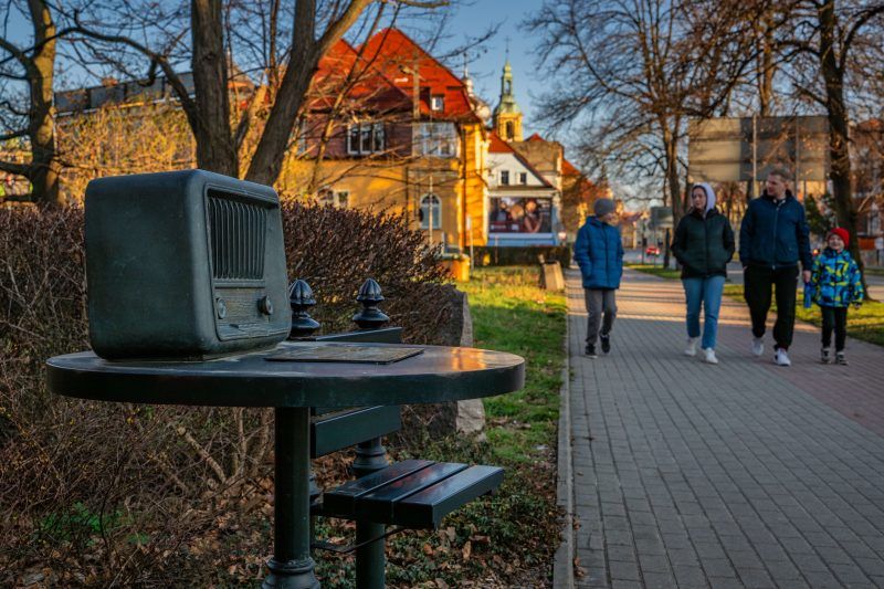 Na stoliku przy scieżce mosiężne radio imitujące pierwsze polskie powojenne radio.