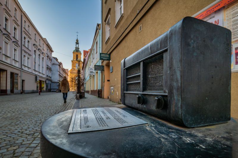 Mosiężne radio, w tle budynki.