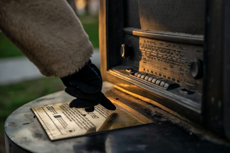 Ręka z palcem wskazującym na tabliczkę przy radio.