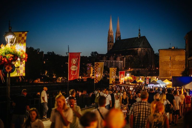 Tłum ludzi spaceruje w godzinach wieczonych po Zgorzelcu podczas imprezy.