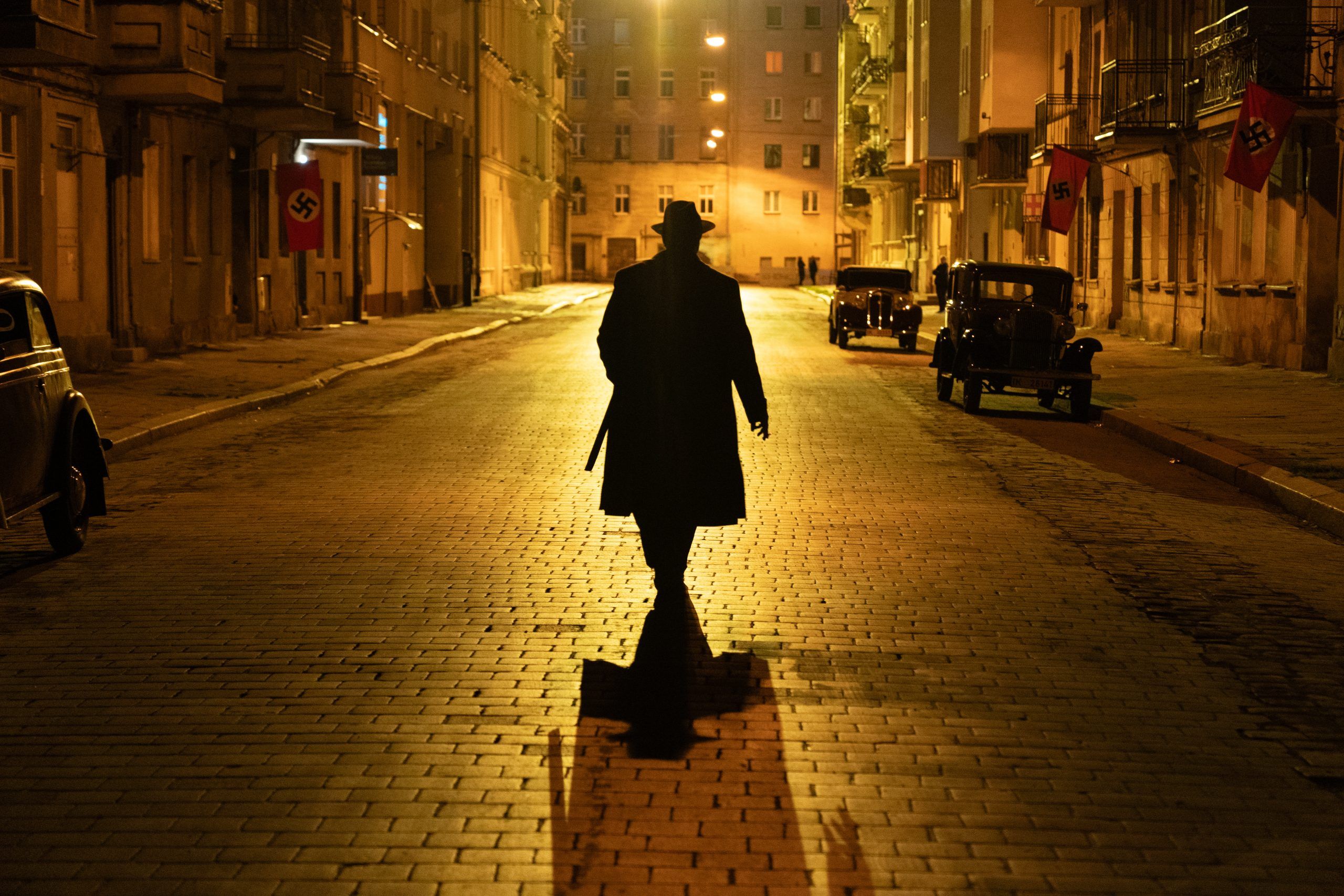 Kadr z filmu z mężczyzną spacerującym nocnymi ulicami miasta z lat 30-tych
