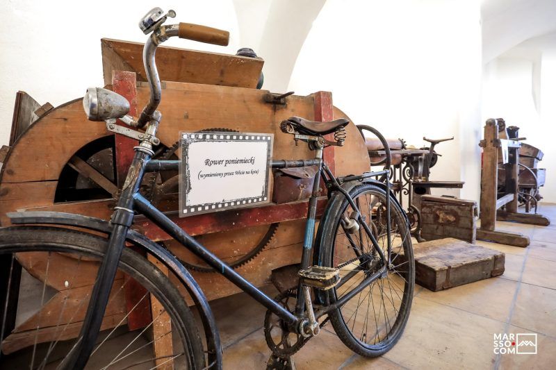 stary czarny rower, oparty o drewniane narzędzie