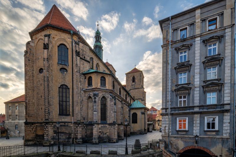 Gotycki kościół z czerwonej cegły i wysoką wieżą.