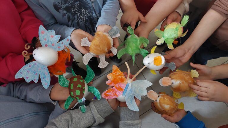 Kolorowe prace dzieci udekorowane podczas warsztatów w Muzeum Przyrodniczym.