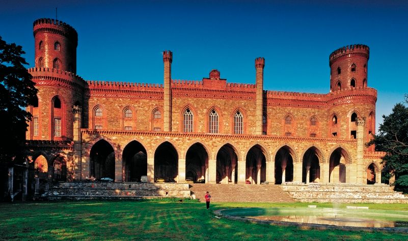 Fasada neogotyckiego pałacu w Kamieńcu Ząbkowickim skąpana w promieniach porannego słońca