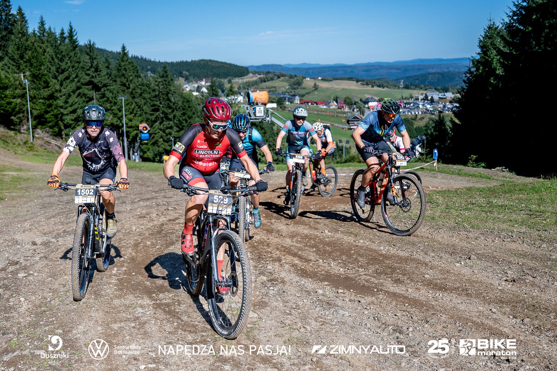 Grupa rowerzystów uchwycona na tle gór i wzniesień w Dusznikach-Zdroju