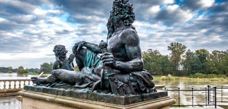 Posąg Viadrusa opierającego sie na ramieniu ujęty na tle zachmurzonego nieba