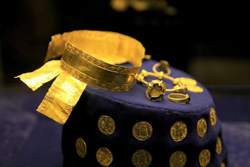 Zdjęcie z bliska złotej opaski monet znalezionych w skarbie