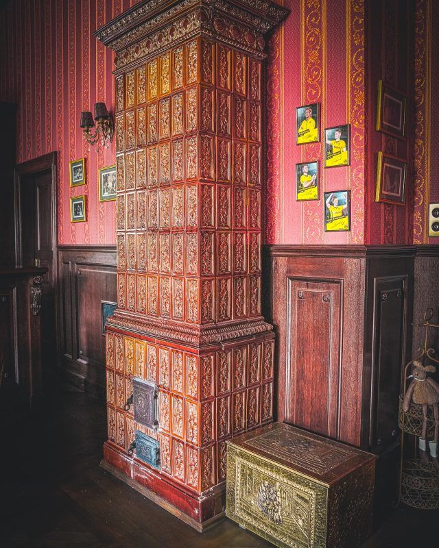 Zdjęcie czerwonego pieca kaflowego w zabytkowych wnętrzach Pałacu Gruszów