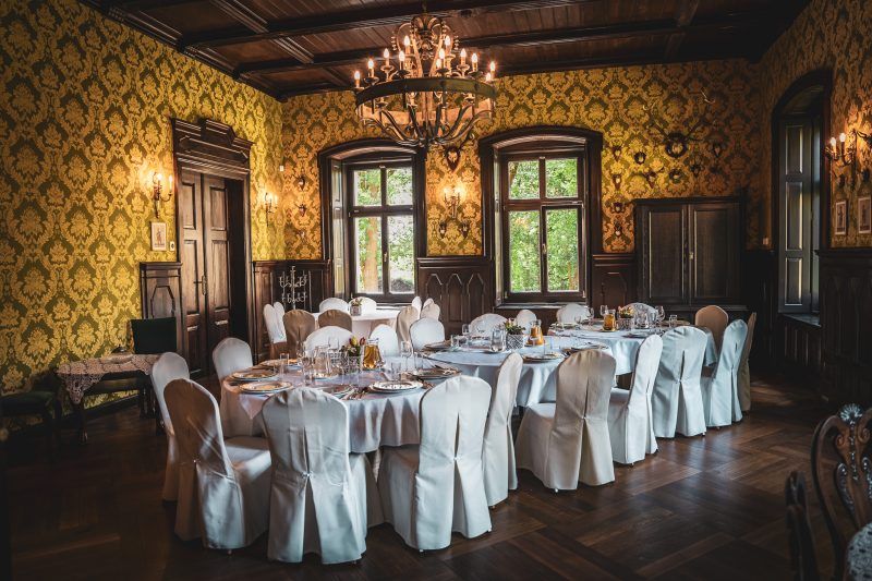 Gustowne wnętrze w restauracji Pałacu Gruszów ze stołem zastawionym na uroczystość