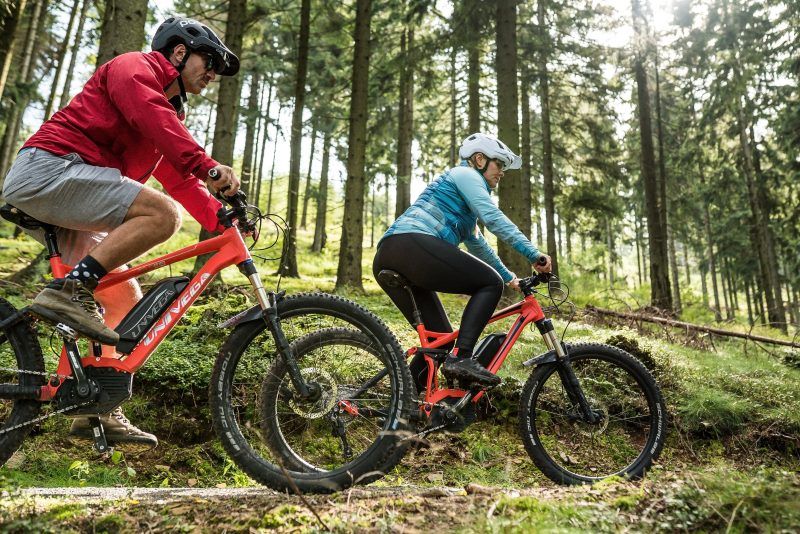 Dwójka rowerzystów podczas jazdy uchwycona od boku