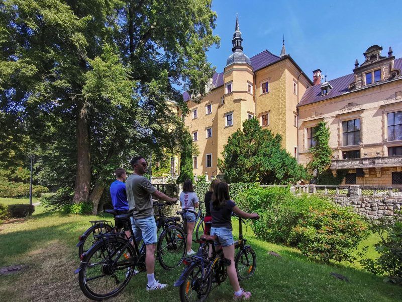 Grupa rowerzystów podczas postoju przy Zamku Kliczków