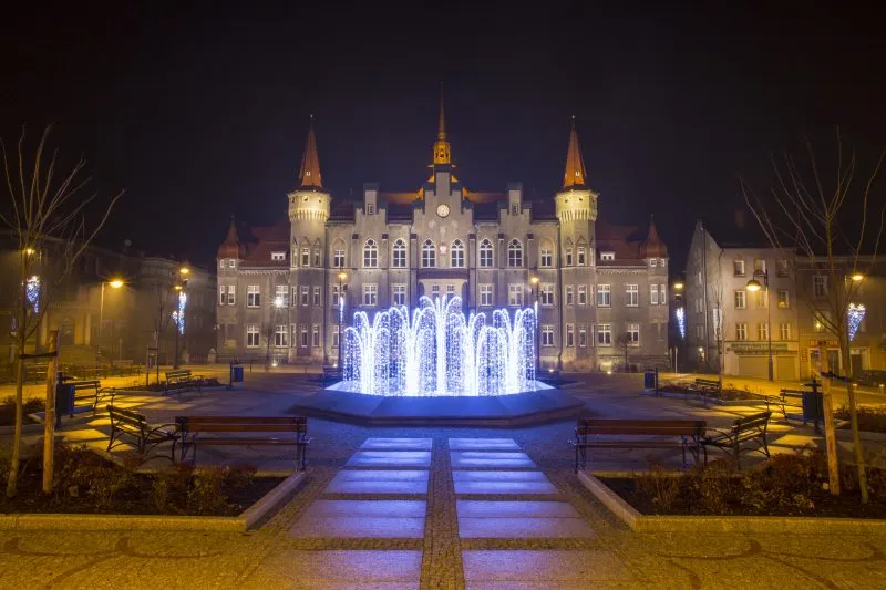 Nocny widok na urząd miasta w Wałbrzychu z podświetloną fontanną na pierwszym planie