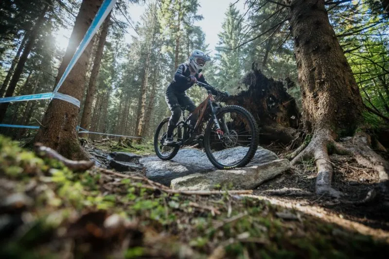 Zdjęcie rowerzysty na trasie górskiego wyścigu rowerowego jadący przez las