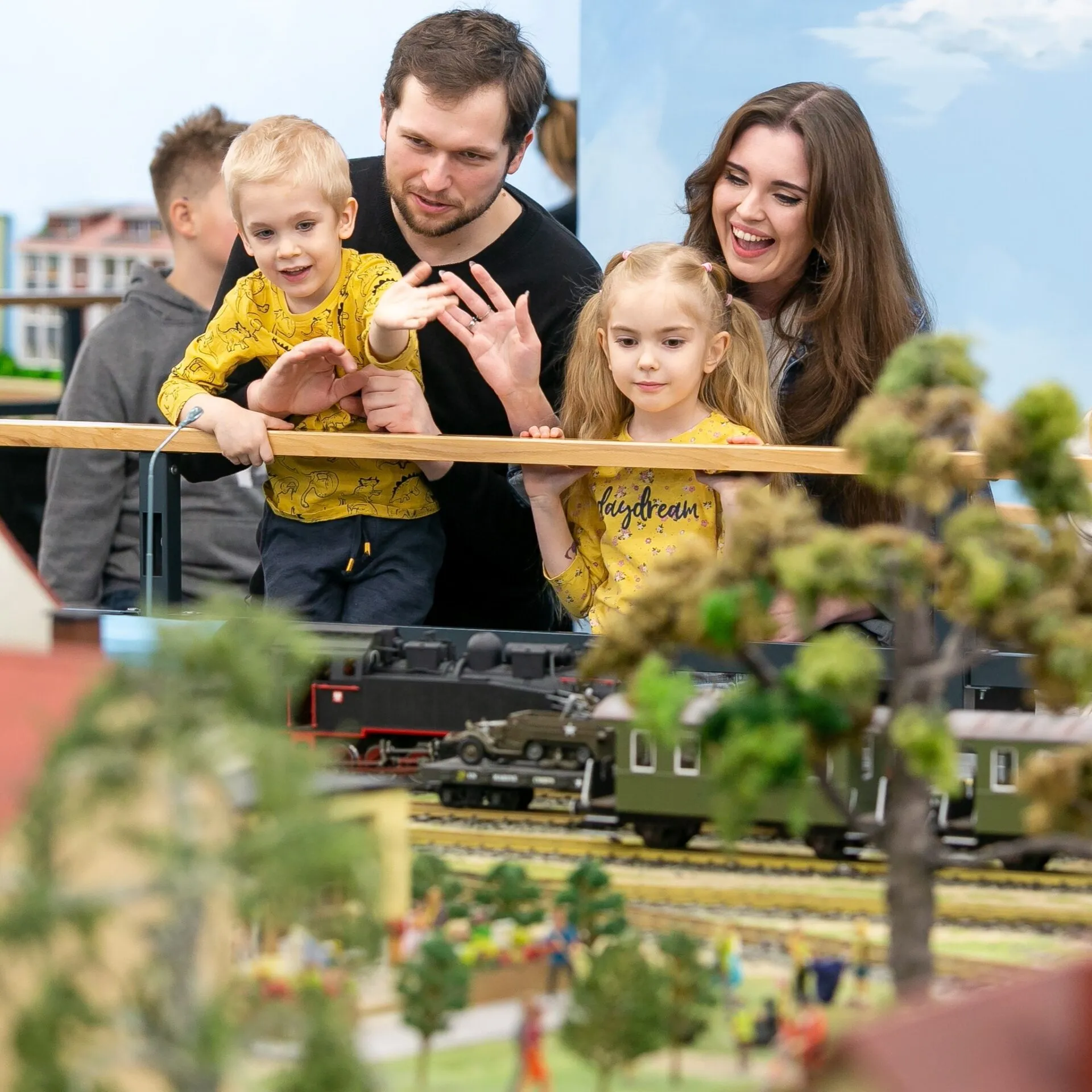 Rodzice z dziećmi oglądają makietę kolejową Kolejkowo