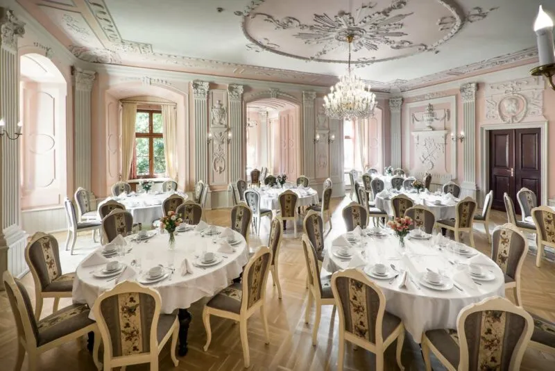 Sala w restauracji zamkowej z pięknie zastawionymi stołami